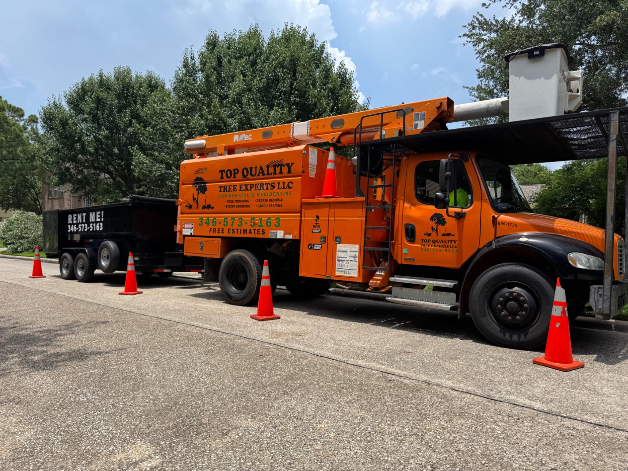 Top Quality Tree Experts bucket trucks and equipment at a job site